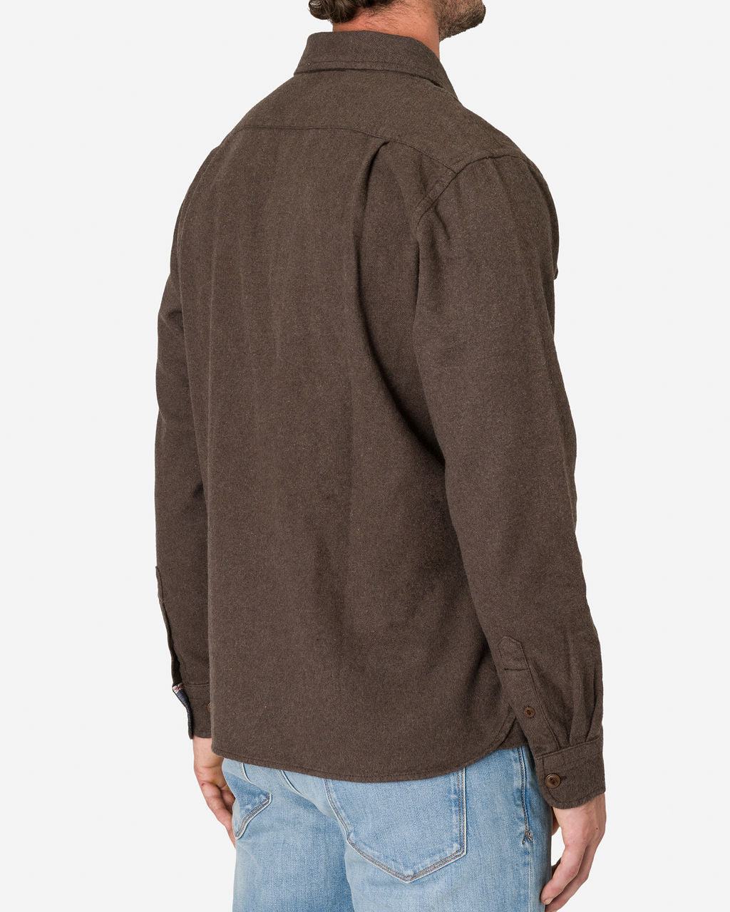 Man wearing a cedar-colored, long-sleeve, utility flannel shirt with buttoned cuffs and a collar, paired with light blue jeans by Ace Rivington, shown from the back.