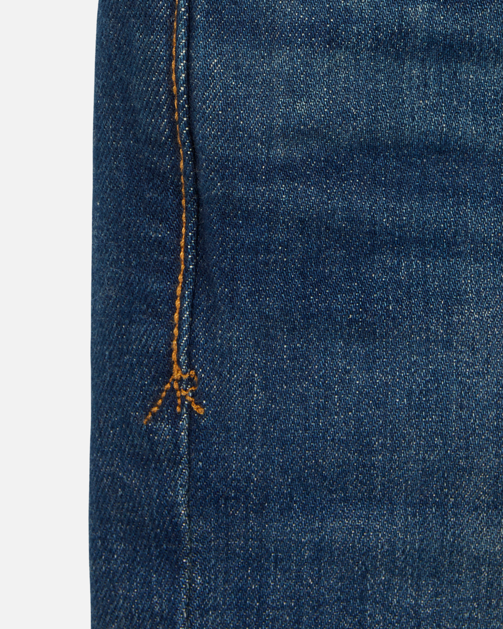 close up of stitching on pair of men's athletic taper blue jeans with slight wear