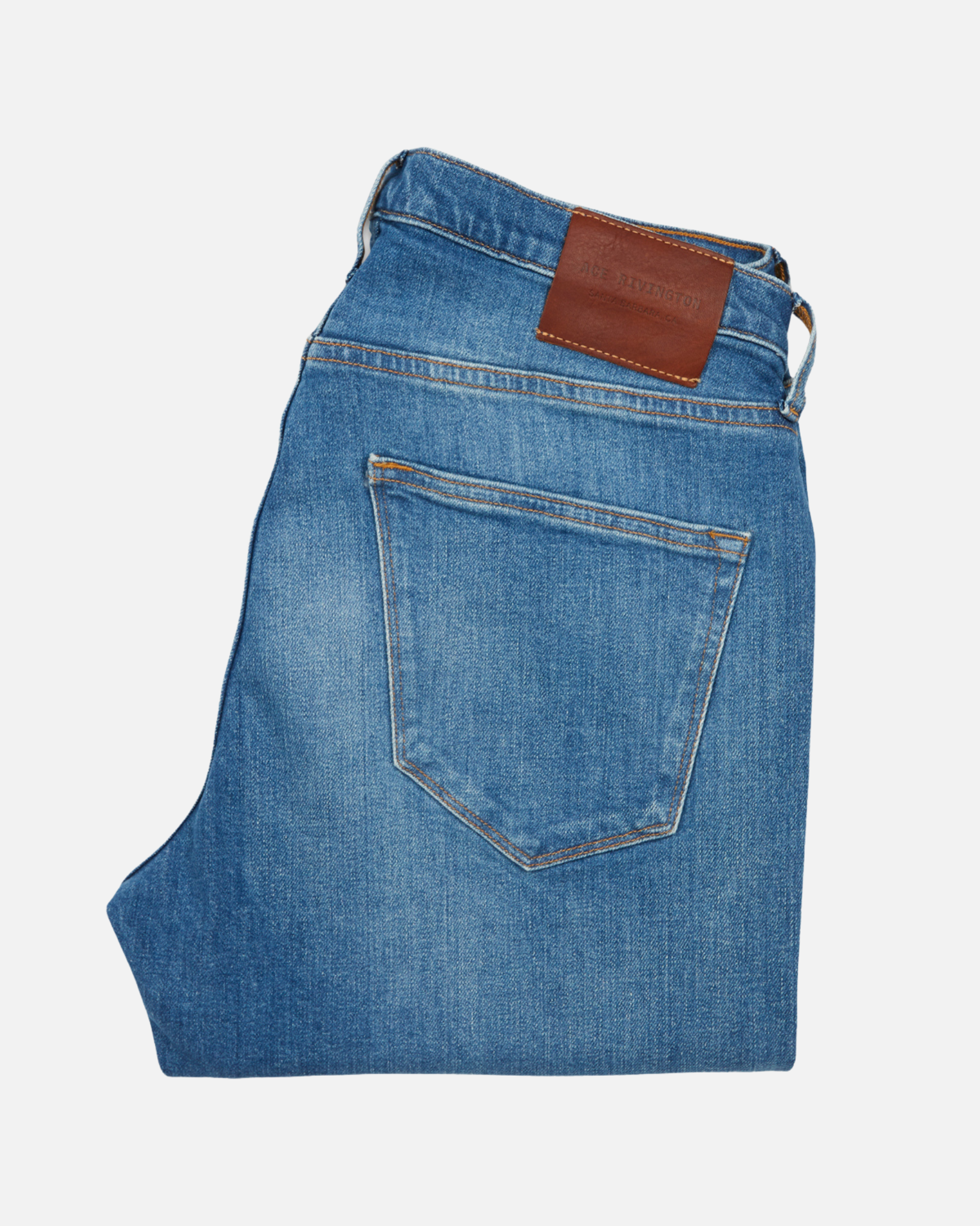 back of folded pair of men's athletic taper medium light blue jeans with slight wear