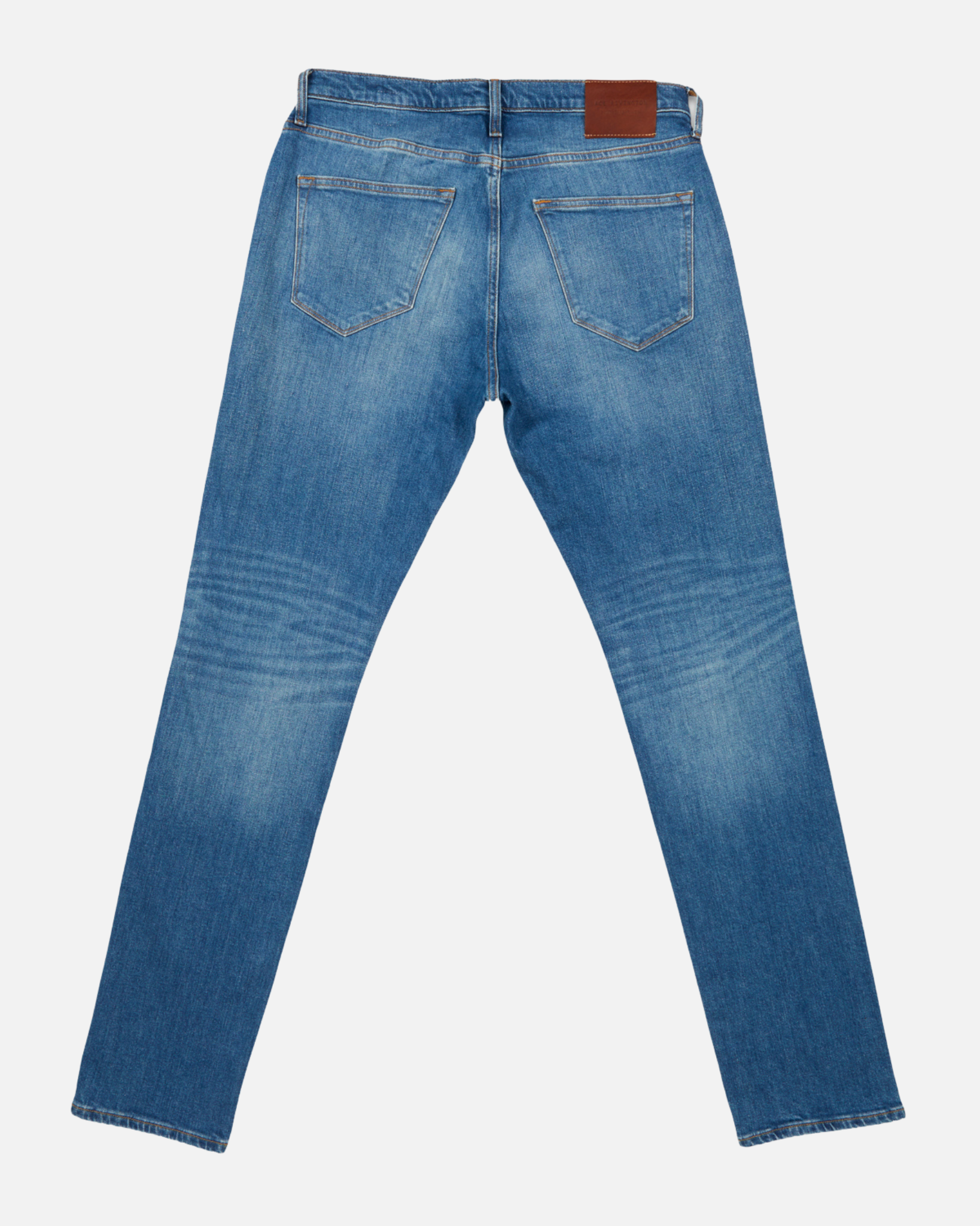 back of folded pair of men's athletic taper medium light blue jeans with slight wear