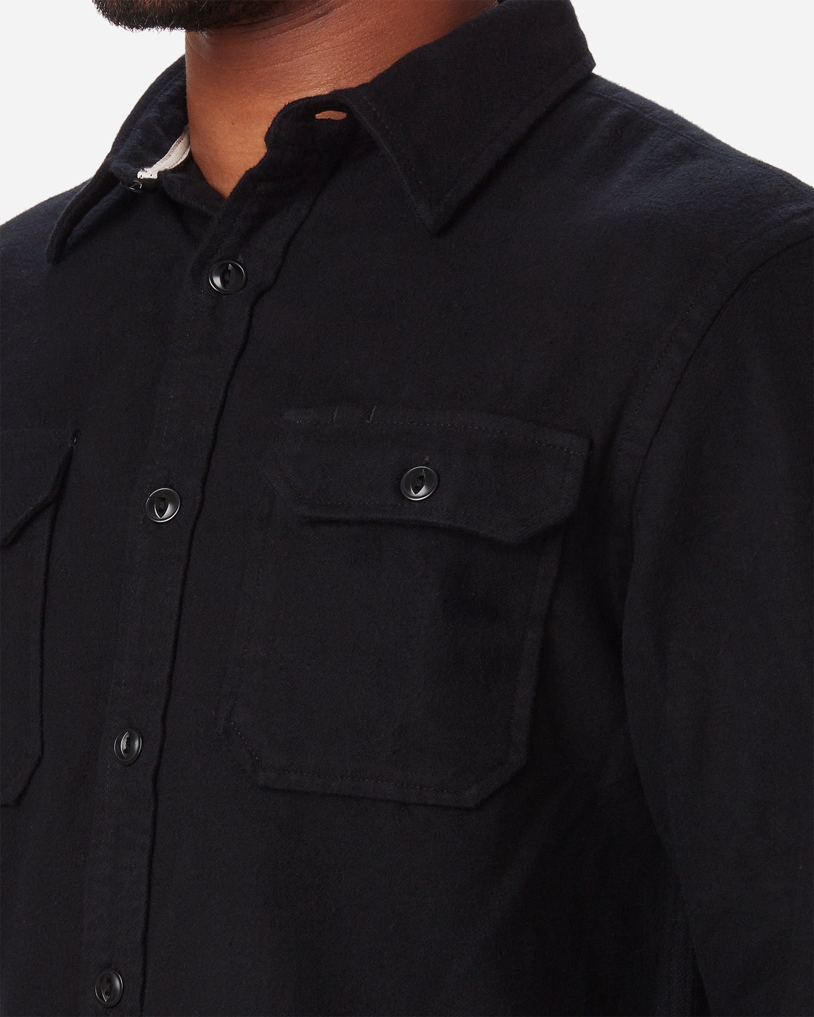 left side of collar, breast pocket, and white interior collar stitching on model wearing Ace Rivington men's black soft brushed flannel shirt 