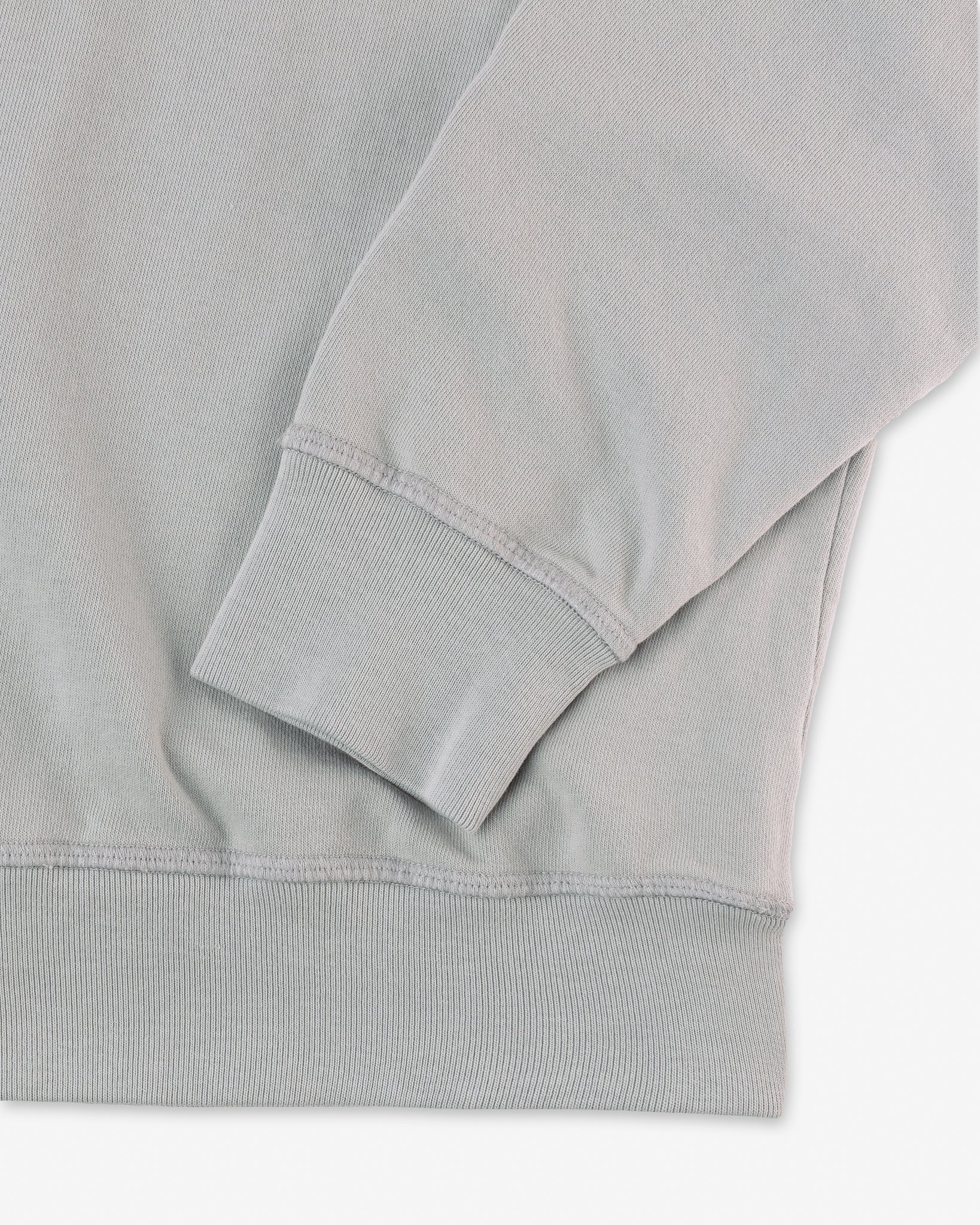 left sleeve set near bottom hem on organic cotton sweatshirt in off-blue