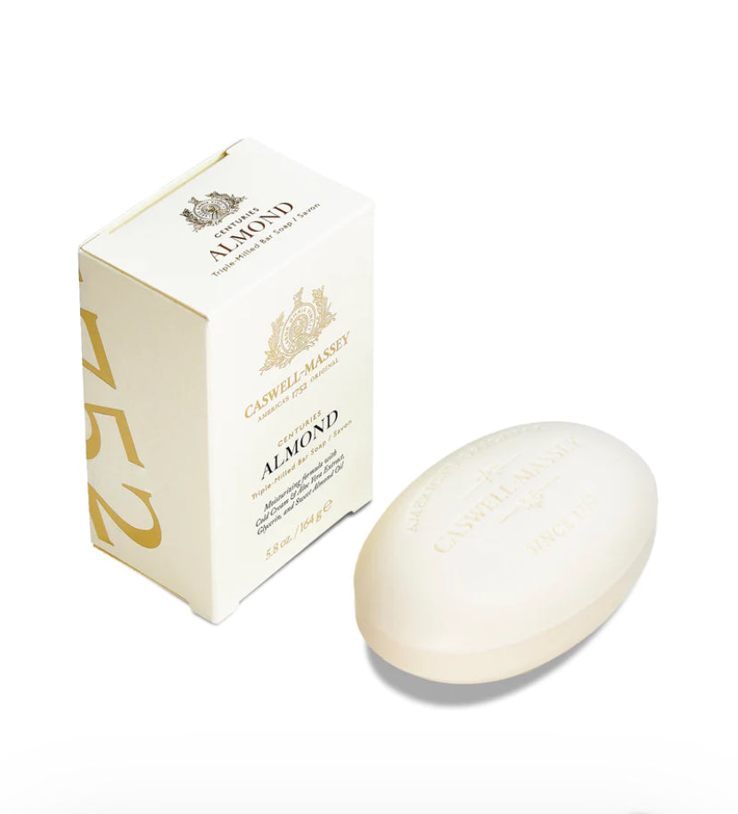 Caswell-Massey Almond Bar Soap zoom-out image same as the first one shows a white rectangular box with gold text and design, and an oval-shaped bar of soap placed next to it. The box features the Caswell-Massey logo and the text 'Centuries Almond' along with details about the product. The soap bar is embossed with similar branding and text.