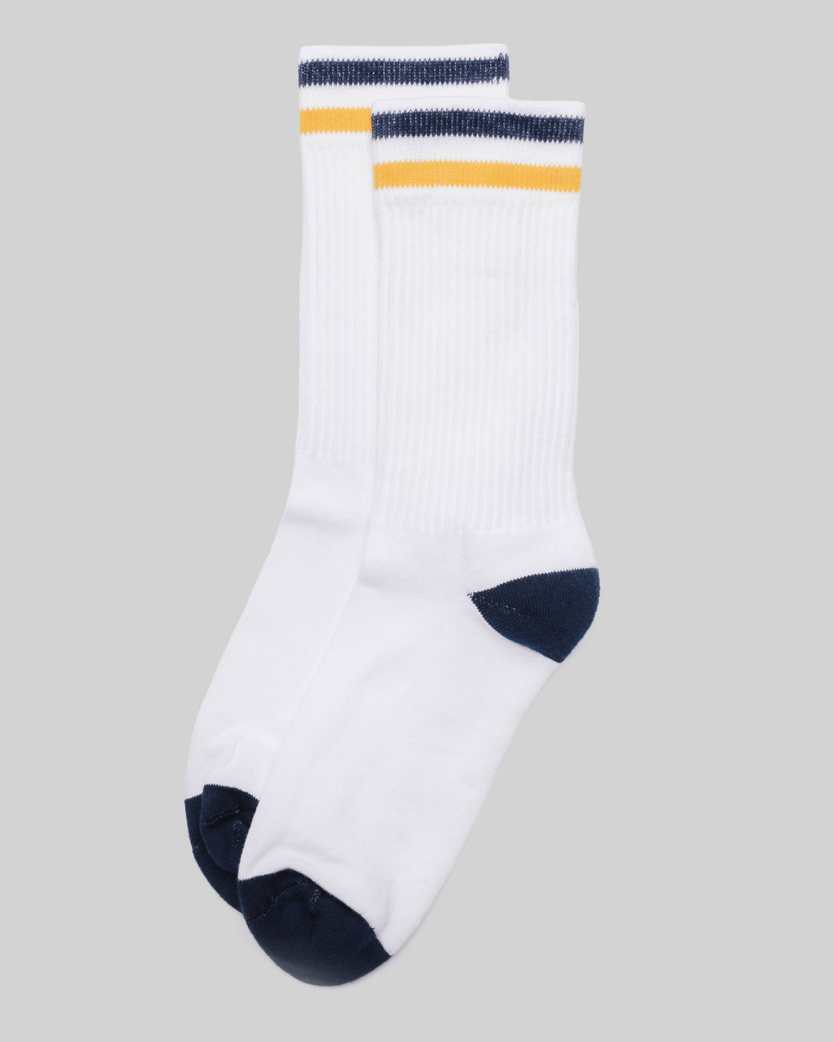 Kennedy Luxe Athletic Socks - White/Navy/Gold laid flat in a top-down view with navy and gold cuff stripes and navy toe and heel on a light grey background.