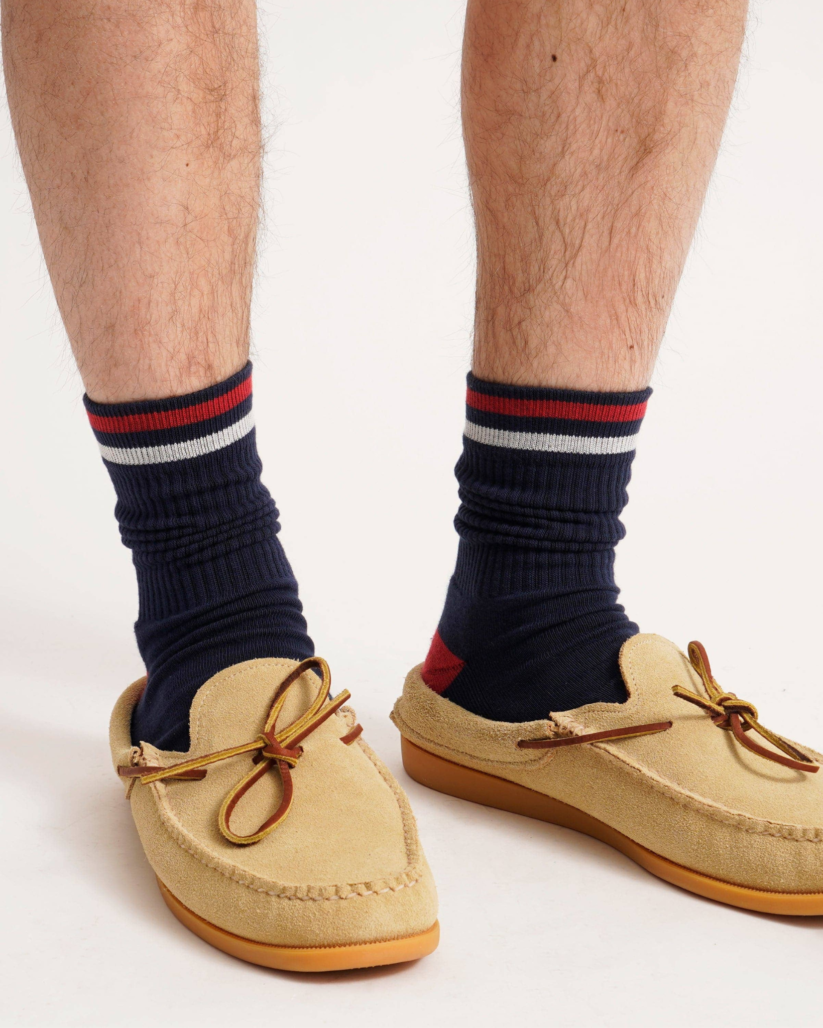 Kennedy Luxe Athletic Socks - Navy/Red/White worn with tan moccasins, shown scrunched at the ankle with visible red heels and cuff stripes in a studio setting.