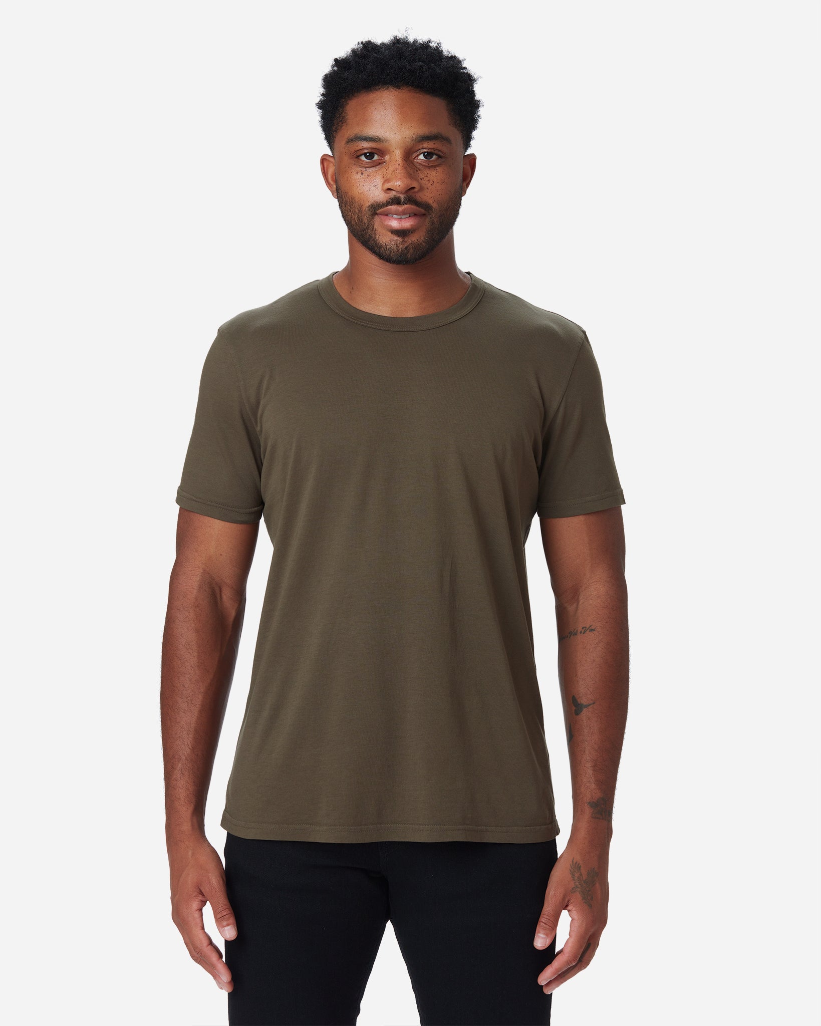 model facing directly forward wearing Ace Rivington dark forest green "military" long staple cotton super soft supima cotton shirt and pair of Ace Rivington black denim jeans