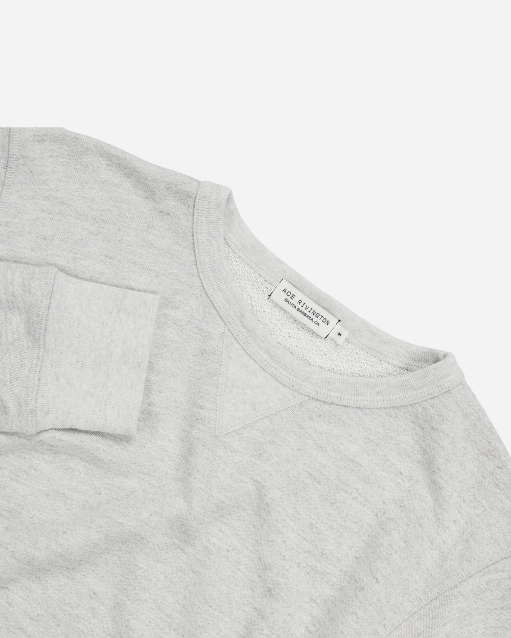 angled aerial view from above of off white grey homespun french terry crew neck sweatshirt with white accent stitching with Ace Rivington logo tag in medium