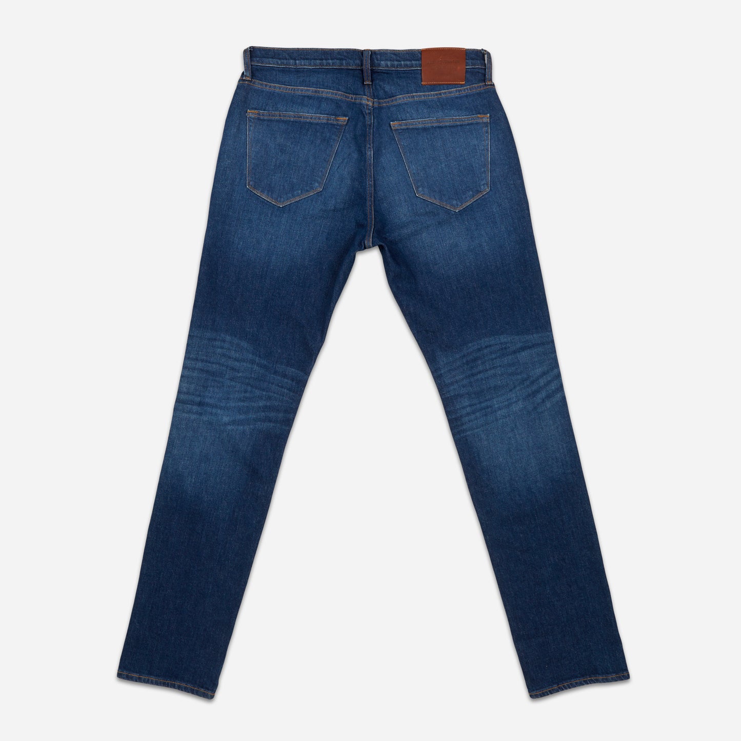 back view of pair of dark blue vintage athletic taper jeans with fully extended legs