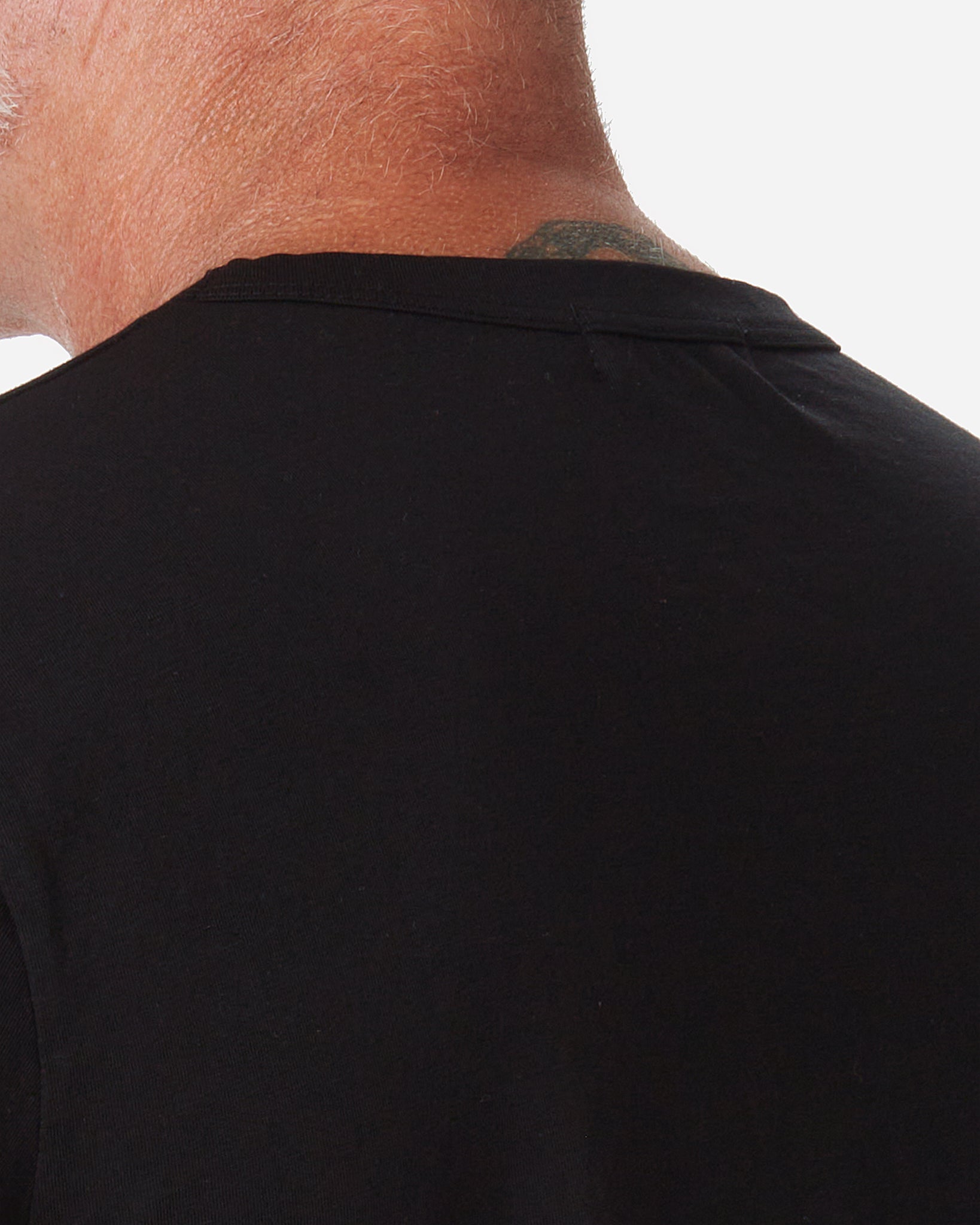 back of neck of model wearing Ace Rivington men's black t shirt made with super soft supima cotton 