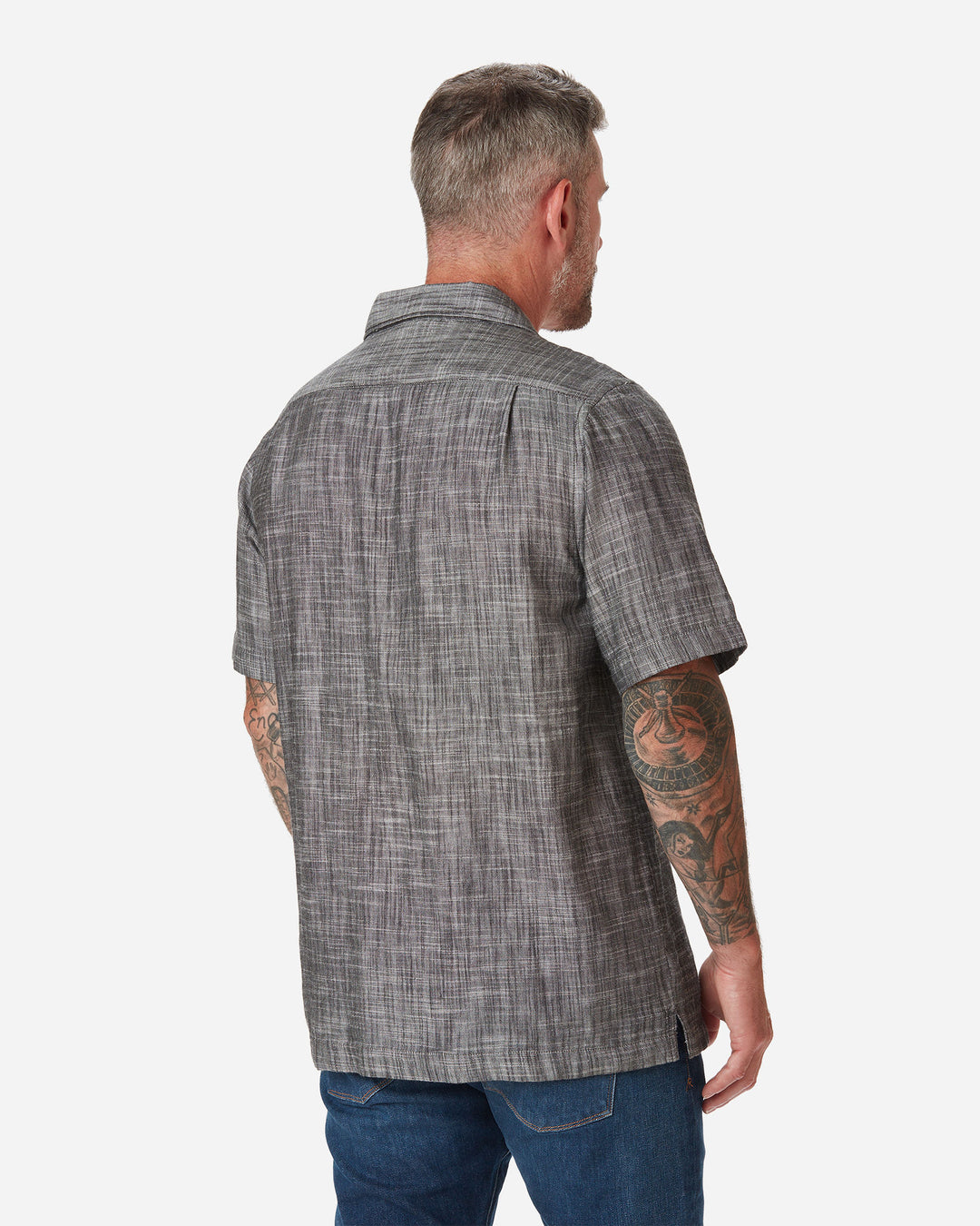 Back of model wearing Ace Rivington "Black" Double gauze soft-textured cotton fabric camp collar shirt with coconut buttons and left-breast pocket and a pair of Ace Rivington dark vintage blue denim jeans