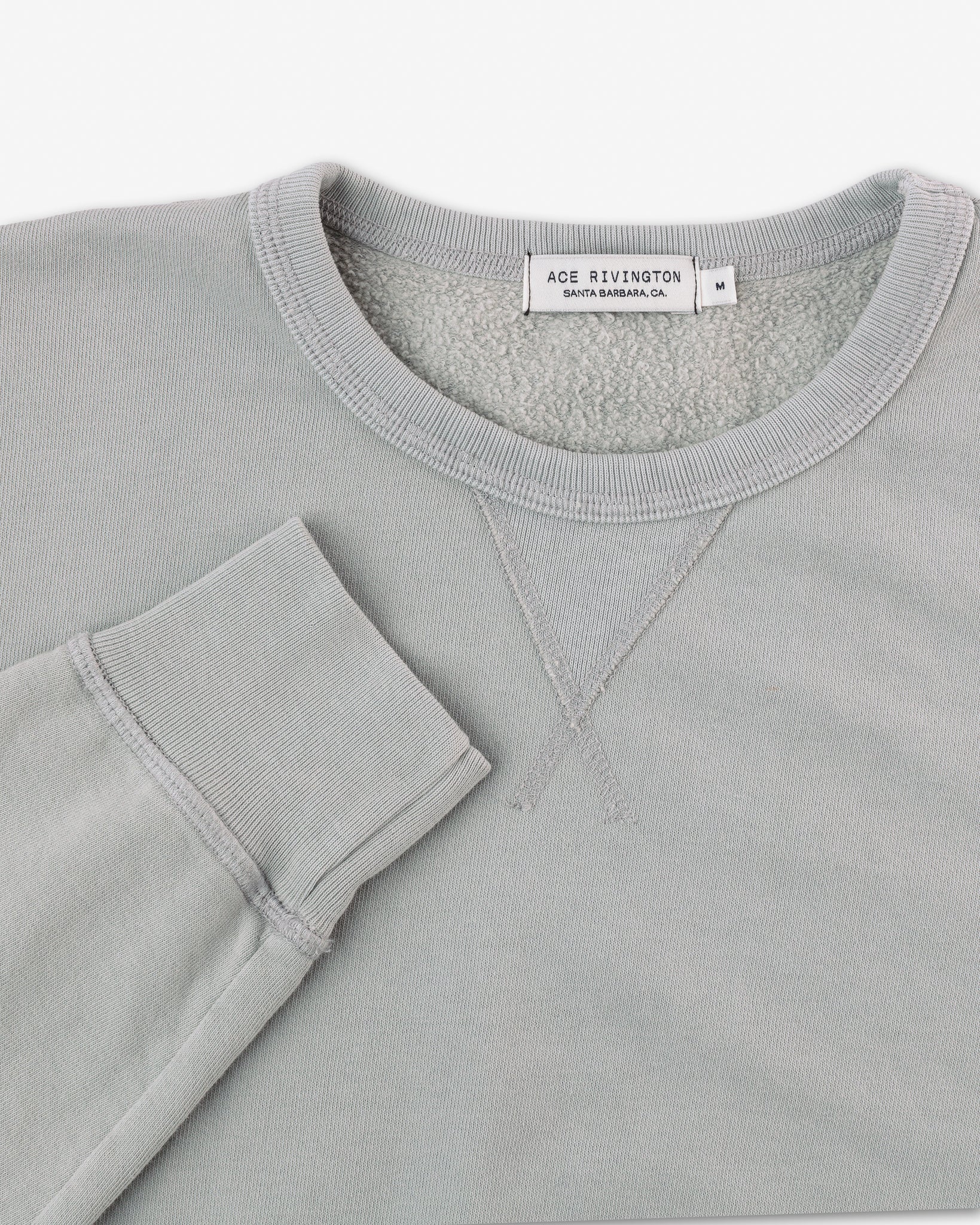 right sleeve set near collar of organic cotton sweatshirt in off-blue