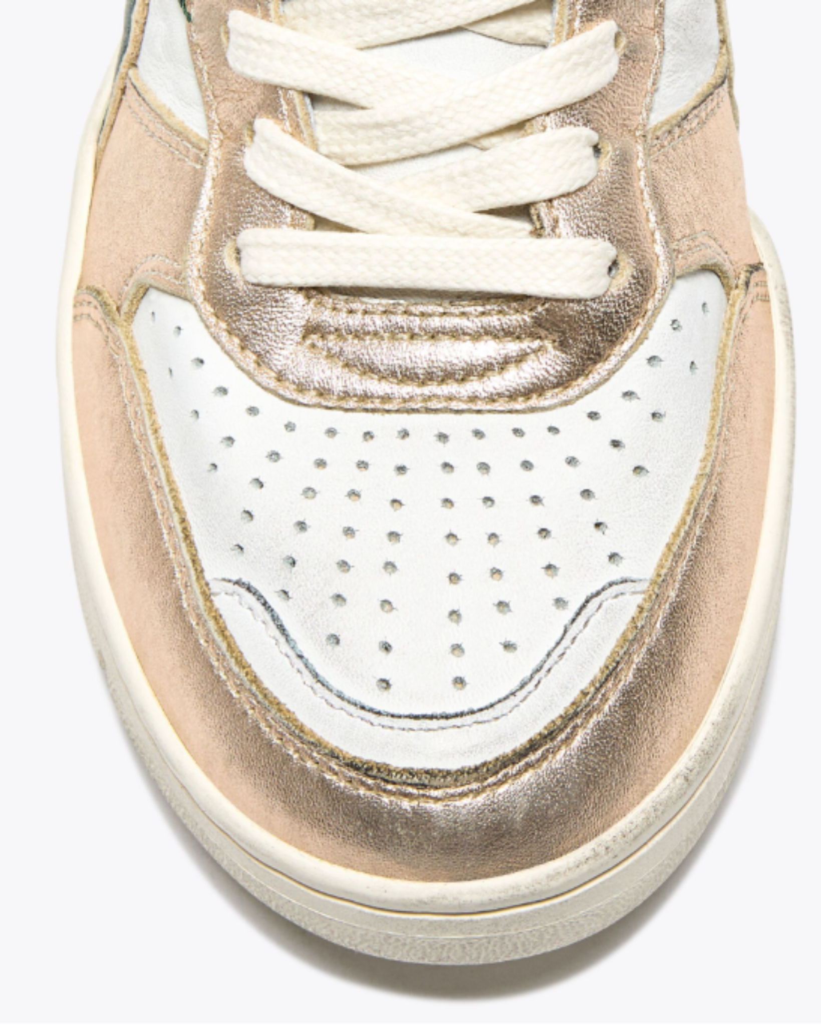 Diadora B. 560 - Metal Mix WN shoe close-up of perforated white leather toe box with metallic gold trim and contrast stitching.