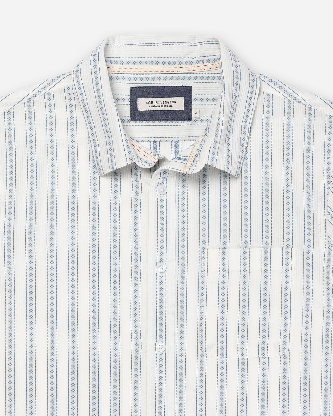 zoomed-in detail shot of tag, collar, and breast pocket on Ace rivington light-weight tailored shirt in off-white with light blue vertical stripes and dark blue diamond pattern within each stripe with pearl buttons and left-breast pocket