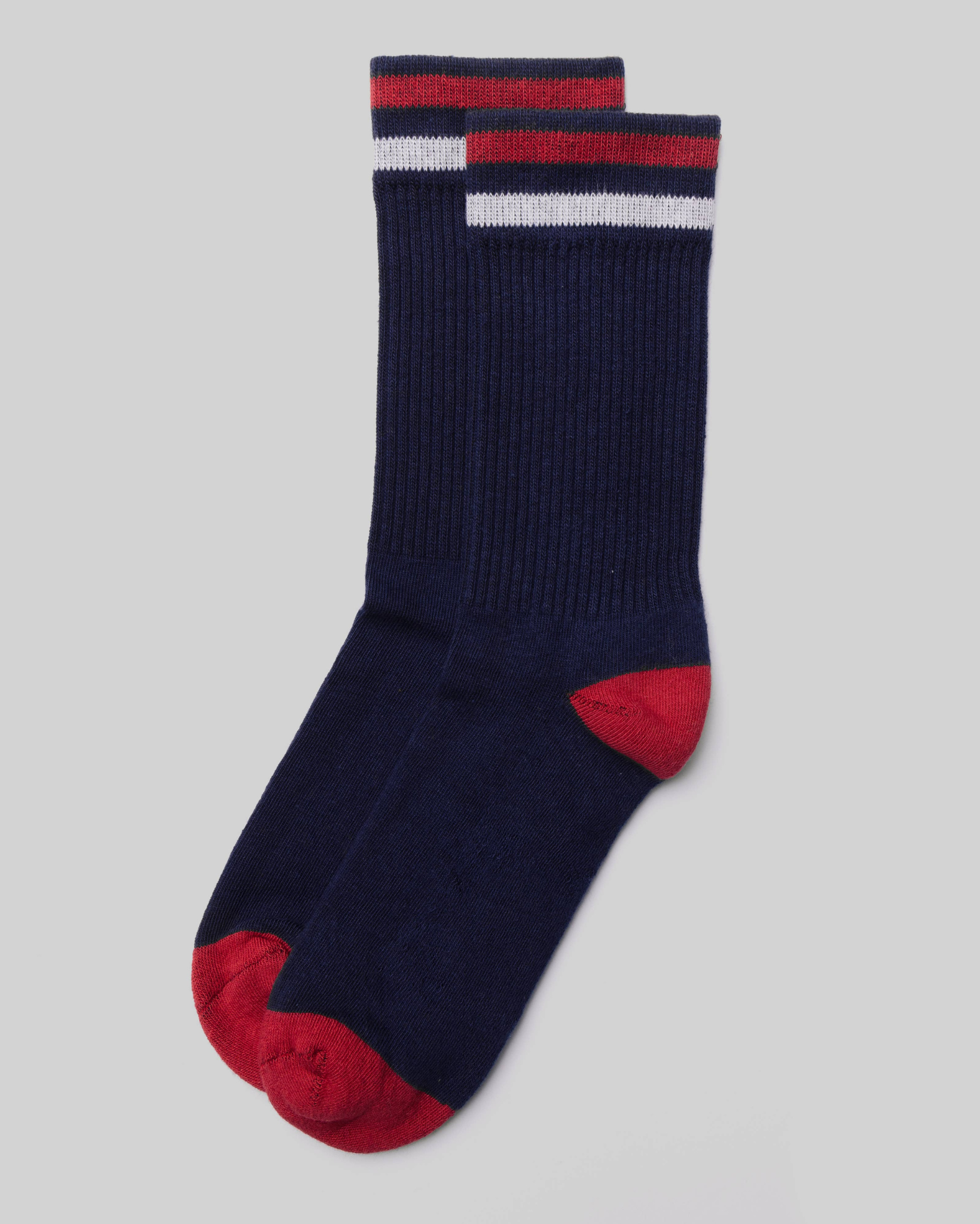 Kennedy Luxe Athletic Socks - Navy/Red/White laid flat in a top-down view with red and white cuff stripes and red toe and heel on a light grey background.