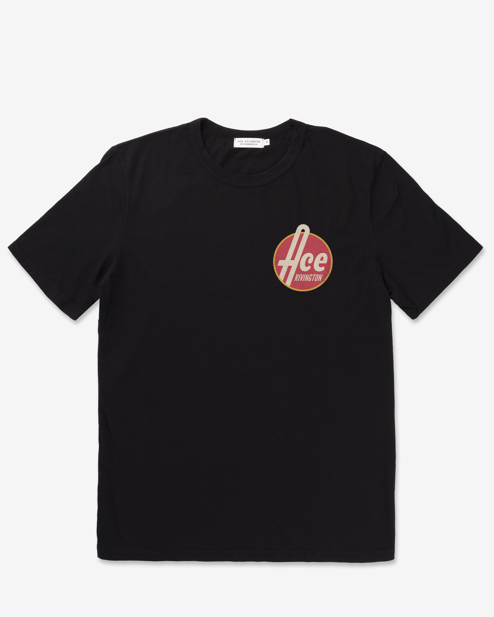 front of men's black graphic tee shirt parodying 1950's style aesthetic reading "Ace Rivington" in bold off-white text encircled by a red fill and gold rim shrunk to palm size on the left breast area