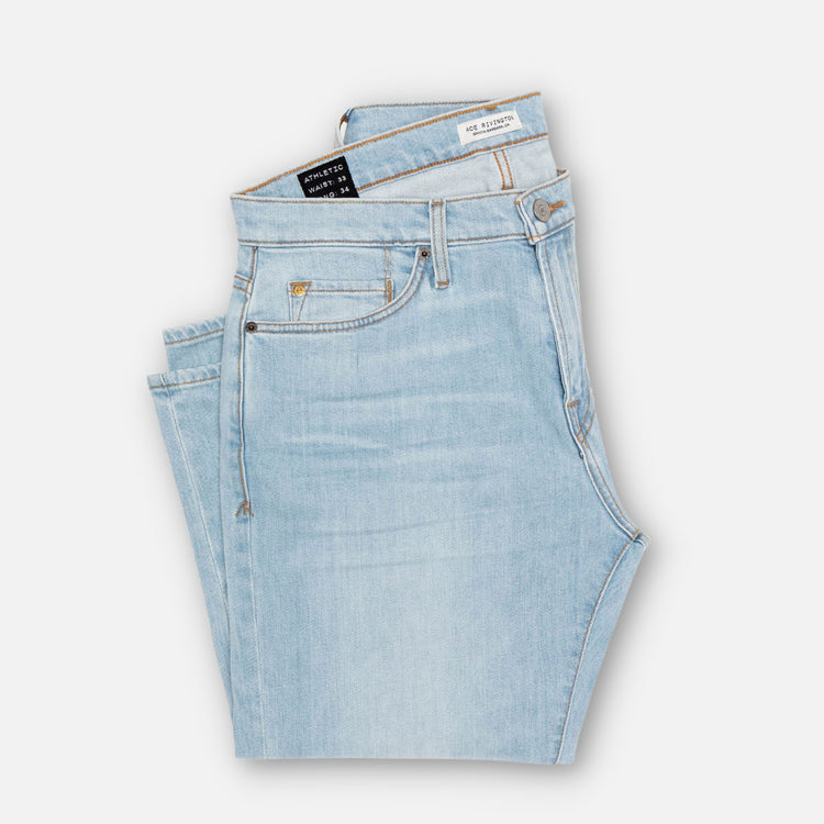 front of folded pair of Ace Rivington super light blue denim jeans with antique nickel detailing