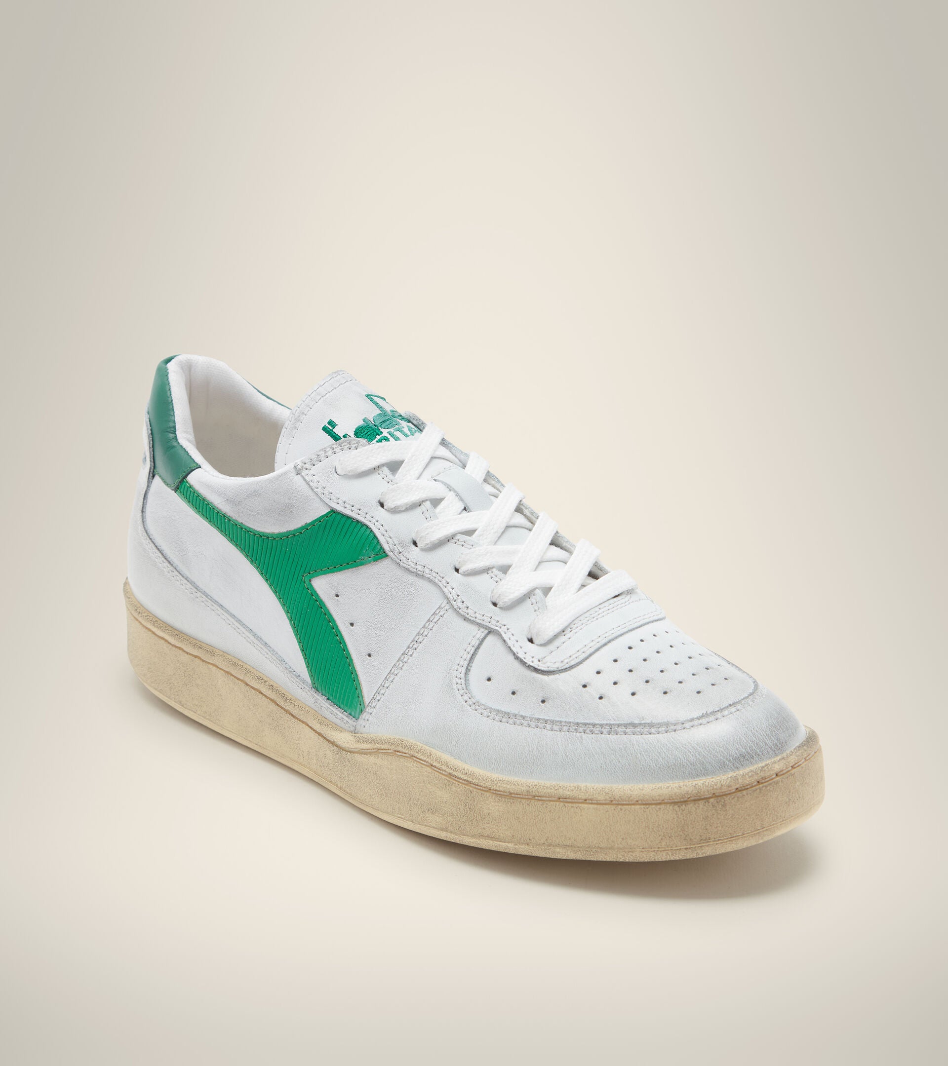 angled view of white diadora men's mi basket low used shoe with a light green stripe