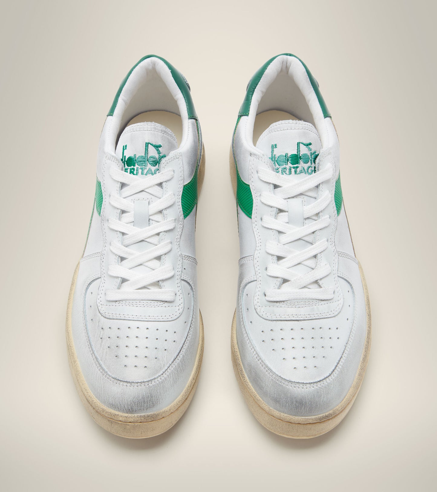 side by side aerial view from above of white diadora men's mi basket low used shoes with a light green stripe