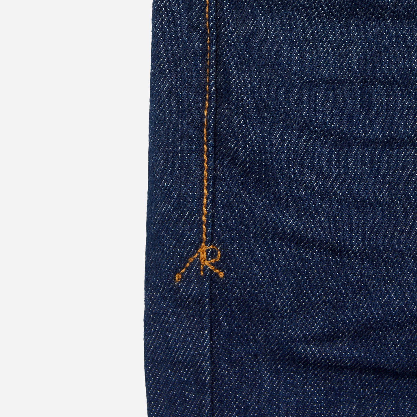 close up of stitching on pair of dark blue athletic taper jeans with no wear