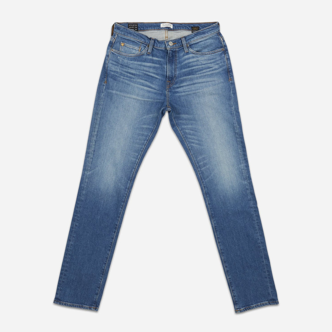 front of fully extended pair of high quality slim cut men's light blue jeans with slight wear