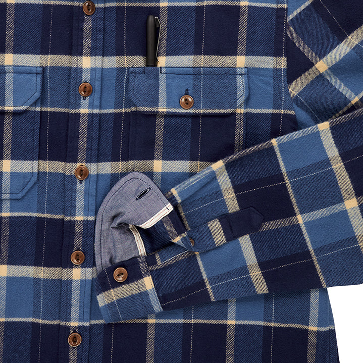 close up of pocket with pen and sleeve cuff on  men's off white dark blue and light blue plaid pattern flannel with brown buttons and white collar stripe in standard height option