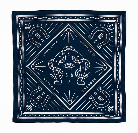 bandana print of snake wrapped around a horseshoe with an eye in the middle surrounded by four other horseshoes with Bs in the middle and the text good luck repeated