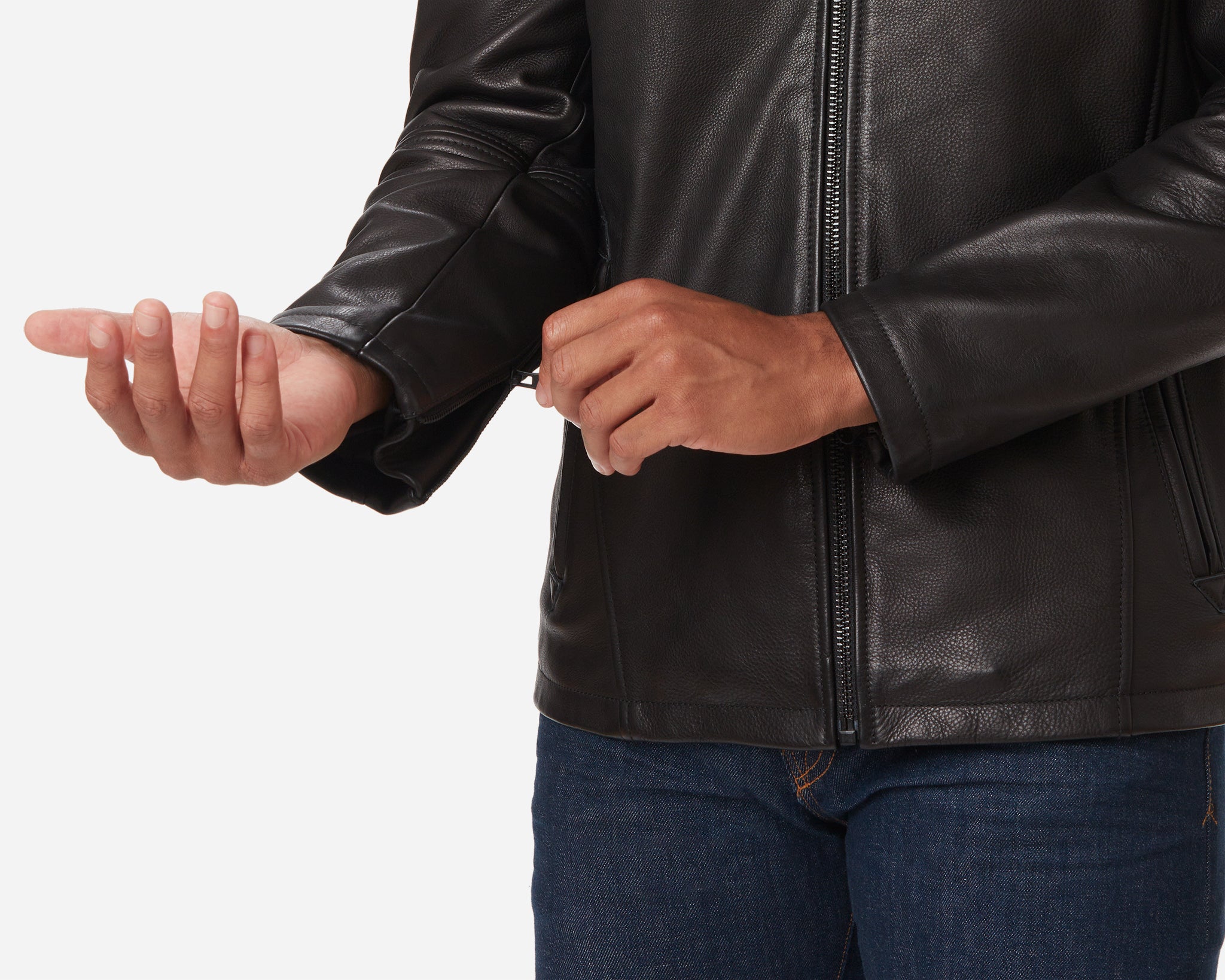 A man wearing a Vintage Black - Cowhide - Cafe Racer Jacket by Ace Rivington adjusting the zipper on the sleeve. The jacket is paired with dark blue jeans.
