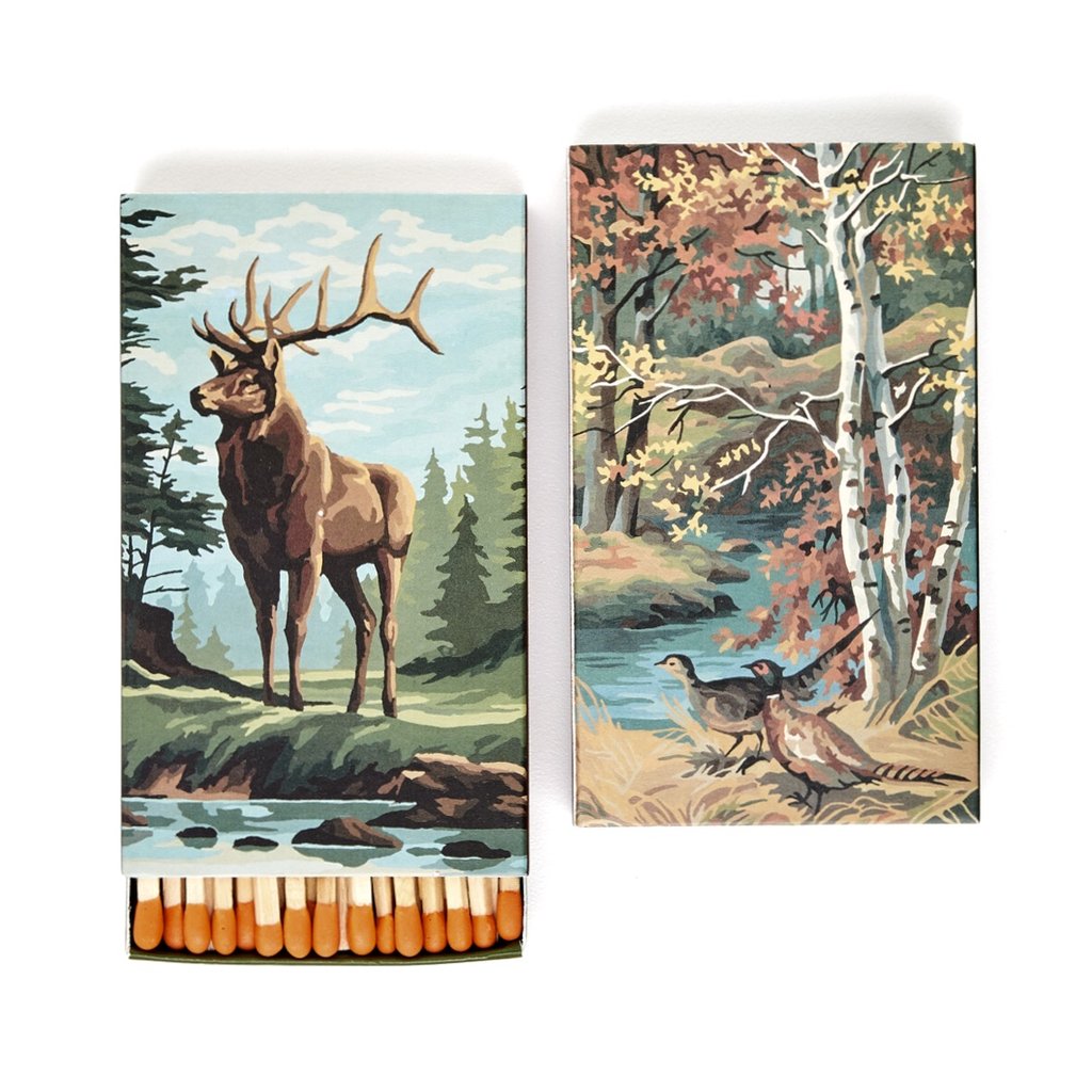 Ace Rivington Mollyjogger Stag Safety Matches. Two matchboxes with illustrated covers. The left matchbox features a majestic stag standing by a stream in a forest, with matches visible at the bottom. The right matchbox depicts a serene forest scene with birch trees, a stream, and two pheasants on the ground.