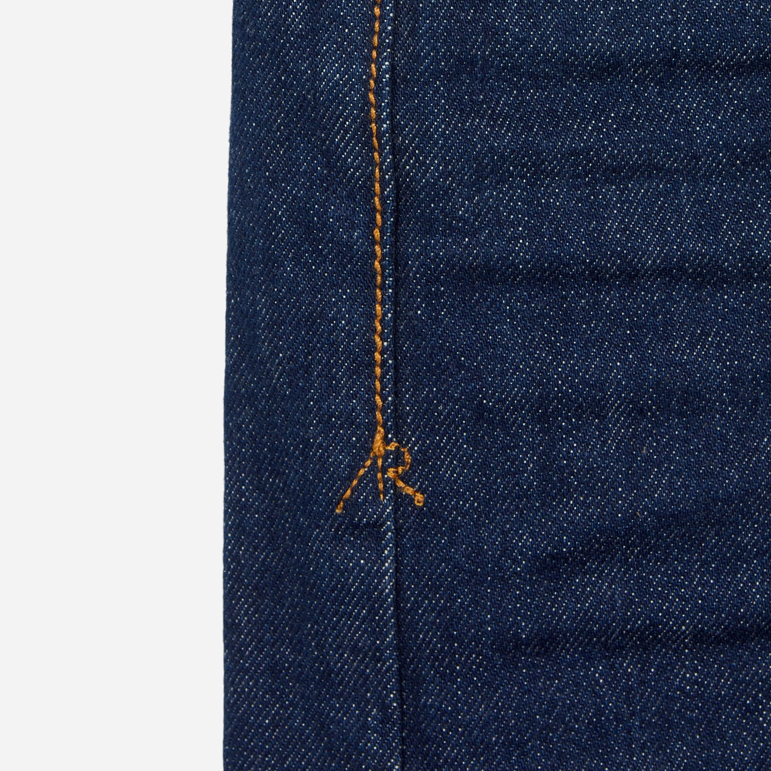 close up of stitching of pair of high quality slim cut men's dark blue jeans with no wear