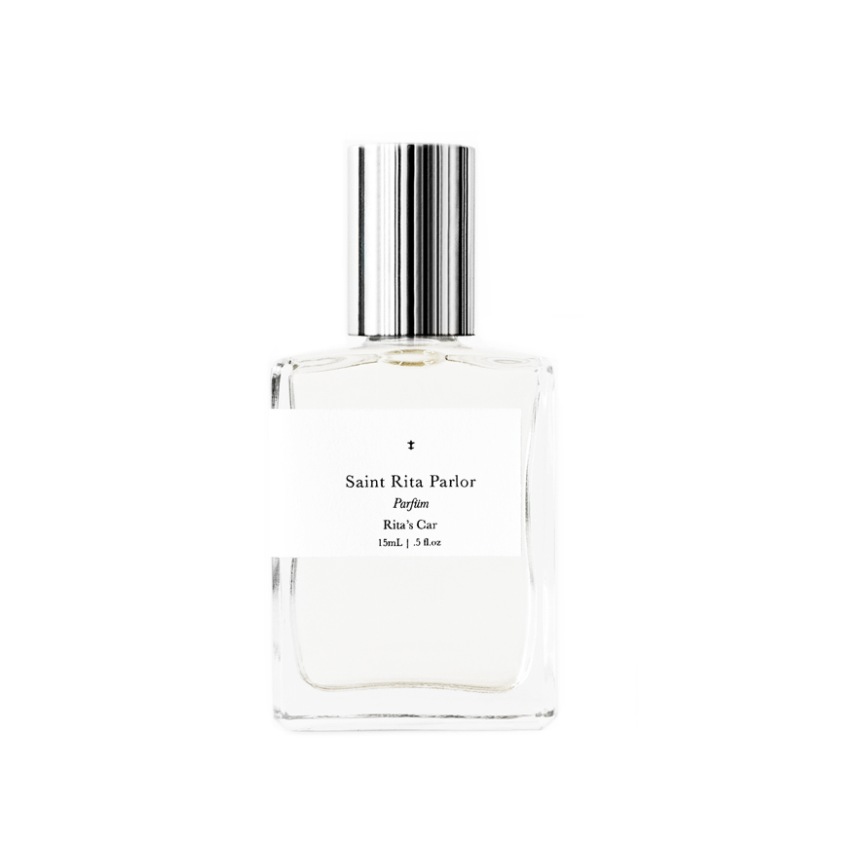 A clear glass bottle of Ace Rivington Saint Rita Parlor - Rita's Car Parfum 15 mL (5.8oz.). The bottle has a minimalist design and the text is in a classic serif font.