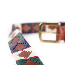 side extended view of tan, white, blue and green western style belt with diamond patterns and gold buckle