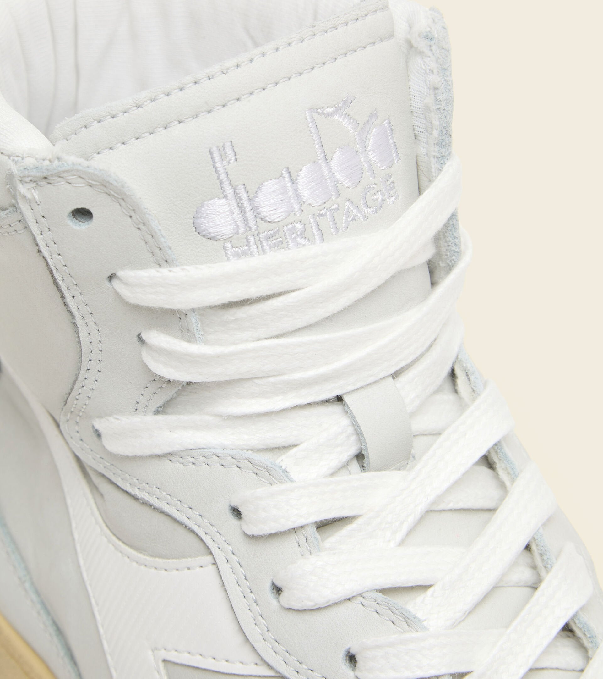 front angled view of diadora white mi basket used shoe with white stripe and beige sole