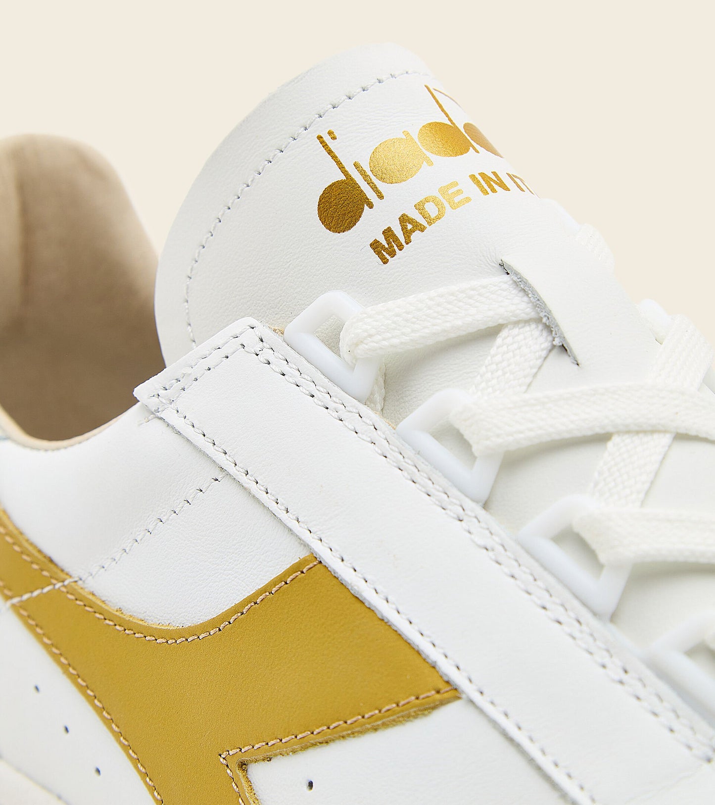 front angle view of white and gold B. elite h italia sport diadora shoe made in italy